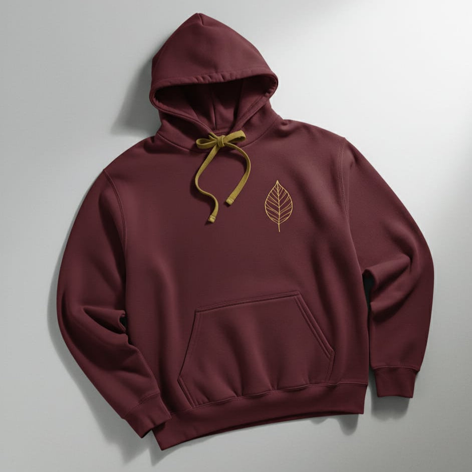 Maroon hoodie with a leaf emblem on a light gray background