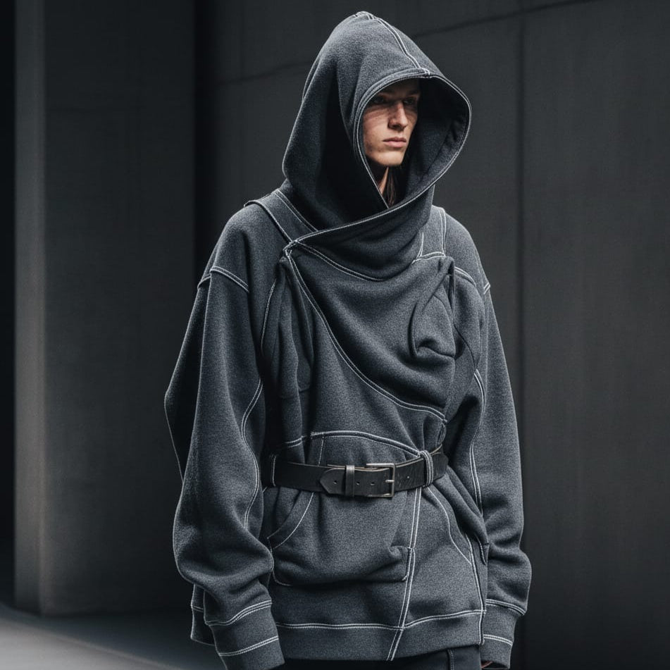 Person wearing a dark gray hoodie with a unique design against a black background